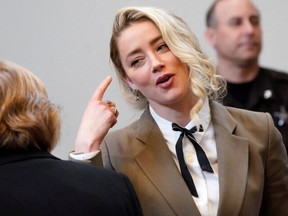 Actor Amber Heard talks to her attorney Elaine Bredehoft during her ex-husband Johnny Depp's defamation case against her, at the Fairfax County Circuit Courthouse in Fairfax, Virginia, U.S., May 23, 2022.