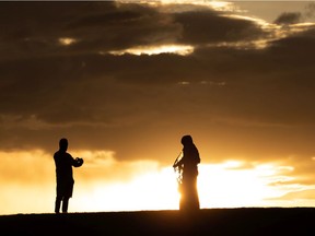A couple takes photos at sunset on Eid al-Fitr at the hill near Walterdale Bridge in Edmonton, on May 13, 2021.