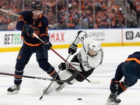 Edmonton Oilers' Ryan Nugent-Hopkins (93) trips up L.A. Kings' Phillip Danault (24) for a penalty during second period of NHL playoff action at Rogers Place in Edmonton, on Monday, May 2, 2022. Photo by Ian Kucerak