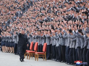 Kim Jong Un waves toward students and young workers, who are all unmasked, during a photo session in Pyongyang, North Korea, in this undated photo released by North Korea's Korean Central News Agency on May 1, 2022.
