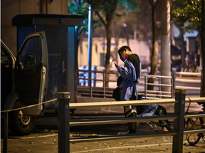 A resident walks on a street through the fence of a compound during a COVID-19 lockdown in the Jing’an district in Shanghai, China, Tuesday, May 3, 2022. Photo by HECTOR RETAMAL /AFP via Getty Images