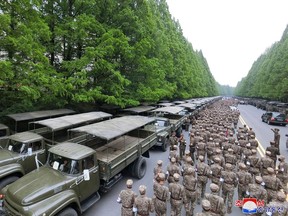 This picture taken on May 16, 2022 and released from North Korea’s official Korean Central News Agency (KCNA) on May 17 shows officers of the military medical field of the Korean People’s Army going to supply medicines to resolve the epidemic prevention crisis over the spread of Covid-19 coronavirus, in Pyongyang. (Photo by KCNA VIA KNS / AFP)