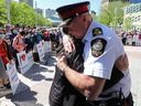 Edmonton Police Chief Dale McFee Embraces Dr.  Holly Mah, president of Chinatown and Area Business Association, as they attend a Chinatown security rally outside City Hall, in Edmonton, Saturday, May 28, 2022. David Bloom-Postmedia