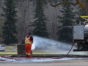 A worker does some spring cleaning, spraying down the grunge accumulated from winter at Hawrelak Park in Edmonton, April 29, 2022. Ed Kaiser/Postmedia