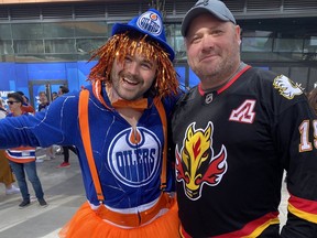 Edmonton Oilers fan Dan Shoemaker poses for a photo alongside Calgary Flames fan, Matt Wahoski at Ice District outside Rogers Place for Game 3 of the Battle Of Alberta on Sunday, May 22, 2022 in Edmonton.