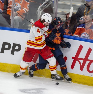 zEdmonton Oilers Kailer Yamamoto (56) battles fore the puck with Calgary Flames Rasmus Andersson (4) during first period NHL second round playoff hockey action  on Sunday, May 22, 2022 in Edmonton.