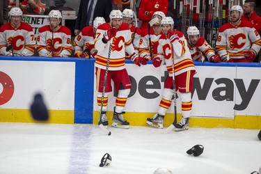 Members of the Calgary Flames watch as the fans throw hats on the ice after Edmonton Oilers Evander Kane (91) scored his third goal of the game for a hat trick during second period NHL second round playoff hockey action on Sunday, May 22, 2022 in Edmonton.