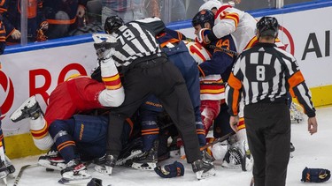 Players pile on Edmonton Oilers goaltender Mike Smith (41) after he is pushed over by Calgary Flames Milan Lucic (17) during third period NHL second round playoff hockey action on Sunday, May 22, 2022 in Edmonton.