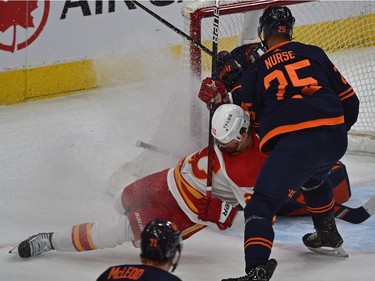 Edmonton Oilers Darnell Nurse (25) takes down Calgary Flames Trevor Lewis (22) during NHL playoff action at Rogers Place in Edmonton, May 24, 2022.