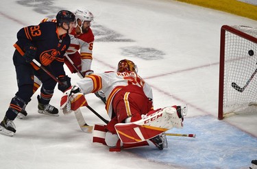 Edmonton Oilers Ryan Nugent-Hopkins (93) watches the puck go into the net with  Calgary Flames Oliver Kylington (58) on goalie Jacob Markstrom (25) for the go ahead goal during NHL playoff action at Rogers Place in Edmonton, May 24, 2022.