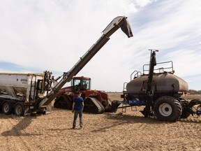 Cecil Goutbeck, left, and Pete Neustaeter seed a field for Share the Harvest's 20th annual crop for the Canadian Foodgrains Bank outside of Gibbons, on Thursday, May 12, 2022.