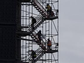 Construction workers walk down the stairs as they finish their shift at a  construction site in Edmonton on Friday, Jan. 22, 2021 in Edmonton. File photo.