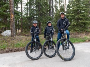 Kane Wolfe, age nine, went through many operations and is now a keen cyclist chosen to be an ambassador in June for Edmonton and Calgary cyclists supporting both the Stollery Children's Hospital and Calgary's Alberta's Children's Hospital foundations. He is pictured here centre with his seven-year-old brother, Maverick Wolfe, and his dad and Wolfe Automotive Group owner, Harrison Wolfe. Photo by Wolfe family.