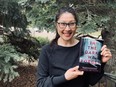 Sandra SG Wong holds her book, In the Dark We Forget, being released in June by HarperCollins.