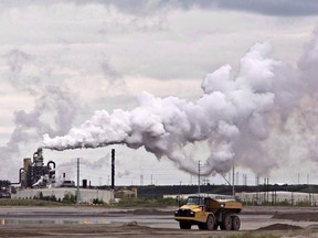 A dump truck works near the Syncrude oil sands extraction facility near the city of Fort McMurray, Alta., on June 1, 2014;