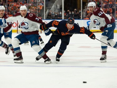 Edmonton Oilers' Zach Hyman (18) is held by Colorado Avalanche's Jack Johnson (3) and Josh Manson (42) during first period of Game 4 of the NHL Western Conference Final action at Rogers Place in Edmonton, on Monday, June 6, 2022.