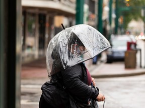 A Woman With An Umbrella Faces A Rainstorm As She Crosses The Intersection Of 104Th Street And Jasper Avenue On Tuesday, June 14, 2022 In Edmonton.  A Storm Hit The Area On Tuesday With Strong Winds And Heavy Rain.