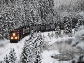 A Canadian Pacific railway locomotive pulls train cars east along a rail line past Morant's Curve near Lake Louise in Banff National Park, Alberta, Canada on November 26, 2021.