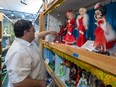 Edward Medeiros, on Monday, June 20, 2022, with Beck Auctions organizes some of the over 700 dolls that went up for auction and are set up in a display after the Valley Doll Museum closed and the contents are being auctioned off.