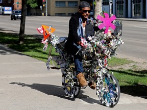 Behar Omer rides the art bike he created along 104 Avenue near 106 Street, in Edmonton Monday June 20, 2022.