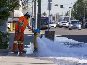 An Epcor worker (he did not want to give his name) measures water pressure at a fire hydrant at 101 Street near 106 Avenue on Thursday, June 2, 2022 in Edmonton.