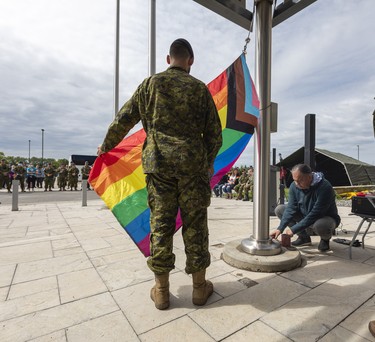 Captain Colin Lussier holds the pride flag while Elder Darin Keewatin blesses it during a Pride flag raising ceremony and Pride walk at Canadian Division Support Base (3 CDSB) to celebrate Pride month on Friday, June 24, 2022 .  This is the first time there has been a Pride parade held at a military base in Canada.