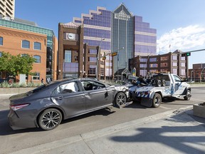 A single vehicle  roll-over that closed Jasper Ave between 97 Street and 100 Street during the morning commute is towed away on Friday, June 3, 2022 in Edmonton.