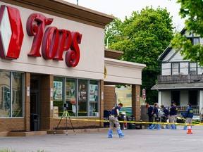 FILE - Investigators work the scene after a mass shooting at a supermarket, in Buffalo, N.Y., May 16, 2022. A white 18-year-old entered the supermarket with the goal of killing as many Black patrons as possible and gunned down 10. That shooter claims to have been introduced to neo-Nazi websites and a livestream of the 2019 Christchurch, New Zealand mosque shootings on the anonymous, online messaging board 4Chan.