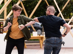 Works Art and Design Festival Executive Artistic Director Amber Rooke (left) and Edmonton International Street Performers Festival Director Paul Bezaire exchange gifts as the two festivals come together for 2022.