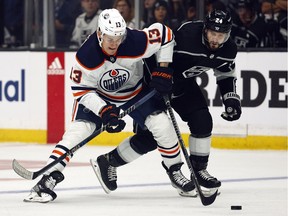 Jesse Puljujarvi (No. 13) of the Edmonton Oilers skates the puck against Phillip Danault (No. 24) of the Los Angeles Kings in the first period of Game 4 of the first round of the 2022 Stanley Cup Playoffs at Crypto.com Arena on May 08, 2022 in Los Angeles, Calif.