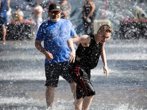 Paul Breslin and his son Parker have a blast in the pool at Churchill Square on a hot day in Edmonton on July 12, 2022.