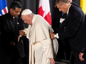 Pope Francis is helped to his wheelchair as he starts his papal visit in Canada after landing at Edmonton International Airport, on Sunday, July 24, 2022. Pope Francis, at 85, traveled from Italy to Canada to apologize for the treatment of Indigenous peoples by the Church.