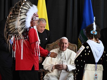 Pope Francis speaks with member of an indigenous tribe during his welcoming ceremony at Edmonton International Airport in Alberta Providence, Canada, on July 24, 2022. - Pope Francis visits Canada for a chance to personally apologize to Indigenous survivors of abuse committed over a span of decades at residential schools run by the Catholic Church. (