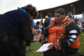 Dennis Lightning (R) offers a smudge ceremony with Buffalo sage to an indigenous community member before the papal visit at Muskwa Park in Maskwacis, Alberta, Canada, on July 25, 2022.