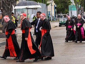 Clergy walk through the rain into the Sacred Heart Church of the First Peoples where Pope Francis will be meeting with members of the Indigenous community in Edmonton, Alberta, Canada, on July 25, 2022. - Pope Francis on Monday apologized for the 