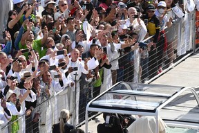 Faithful cheer as Pope Francis arrives for an open-air mass at Commonwealth Stadium in Edmonton, Canada, on July 26, 2022. - The Pope with be celebrating the feast of St. Anne, grandmother of Jesus, a day of particular reverence for Indigenous Catholics.