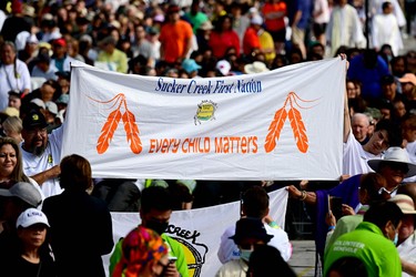 People display a banner reading "Sucker Creek First Nation Every Child Matters" as Pope Francis arrives for an open-air mass at Commonwealth Stadium in Edmonton, Canada, on July 26, 2022. - The Pope will be celebrating the feast of St. Anne, grandmother of Jesus, a day of particular reverence for Indigenous Catholics.