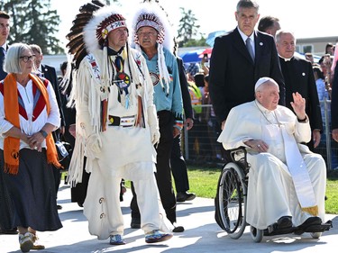 A member of the Alexis Nakota Sioux Nation walks alongside Pope Francis as he arrives to participate in the Lac Ste. Anne Pilgrimage and Liturgy of the Word at Lac Ste. Anne, northwest of Edmonton, Alberta, Canada, July 26, 2022.