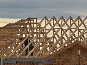 A construction worker in the what will be the attic of a house with only the rafters up underconstruction along 153 Ave. in north Edmonton, October 5, 2020.