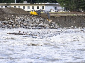 An excavator places rock along a bend in the Coquihalla River in Hope, B.C., Thursday, Dec. 2, 2021. The River Forecast Centre has issued another flood watch as heavy rains swell a waterway that winds through parts of Kelowna, B.C. The centre says flows on Mission Creek increased rapidly overnight and will continue to rise through Tuesday with additional rainfall.