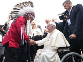 Pope Francis is greeted by George Arcand, Grand Chief of the Confederacy of Treaty Six First Nations, as he arrives in Edmonton on Sunday, July 24, 2022. His visit to Canada is aimed at reconciliation with Indigenous people for the Catholic Church’s role in residential schools.