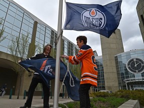 MacEwan University president and vice-chancellor, Dr. Annette Trimbee raising a Oilers flag as Myles Dykes, president of the Students' Association holds up another, as they enter a friendly wager with Mount Royal University in Calgary on the result of the Battle of Alberta playoff series, at MacEwan University in Edmonton, May 18, 2022. Both universities will be fundraising during the series to donate to their student foodbanks.