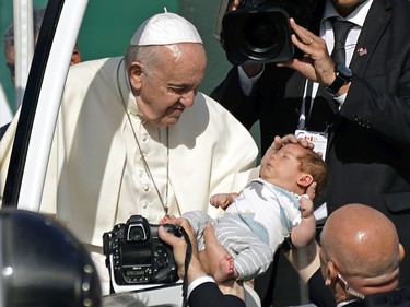 Pope Francis, the head of the Roman Catholic Church, blesses a baby upon arrival at Commonwealth Stadium in Edmonton, Canada to deliver an outdoor mass on Tuesday July 26, 2022. The pontiff is on a penitential pilgrimage to Canada to apologize for the role that the Catholic Church had in residential schools in Canada.