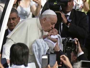 Pope Francis, the head of the Roman Catholic Church, kisses a baby upon arrival at Commonwealth Stadium in Edmonton, Canada to deliver an outdoor mass on Tuesday July 26, 2022. The pontiff is on a penitential pilgrimage to Canada to apologize for the role that the Catholic Church had in residential schools in Canada.