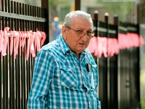 Orange ribbons in memory of the victims of Canada's residential school system are visible behind Community Elder Fernie Marty as he speaks to the media outside Sacred Heart Church of the First Peoples, in Edmonton, Monday July 18, 2022.