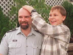 Edmonton police Sgt. Gary Goulet has his head inspected by Chance Johnson, a brain-tumor survivor left blinded by his fight with cancer, in this file photo from March 1996.