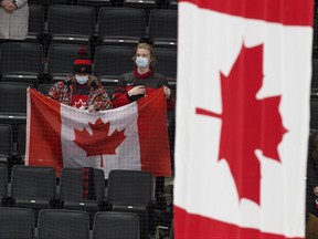 In this Dec. 28, 2021 file photo, Team Canada fans watch as the Canadian flag is raised following the team's win over Team Austria at the IIHF World Junior Hockey Championship in Edmonton.