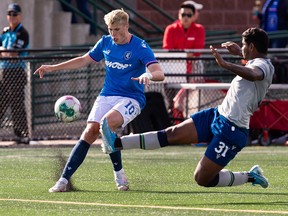 FC Edmonton's Tobias Warschewski (10) tackles Halifax Wanderers' Eriks Peieira (31) during a Canadian Premier League soccer match at Clarke Stadium in Edmonton on Sunday August 28, 2022.