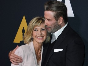 In this file photo taken on August 15, 2018 actors Olivia Newton-John and John Travolta pose on the red carpet as they arrive for the 40th anniversary celebration of the movie "Grease" at the Academy of Motion Picture Arts and Sciences (AMPAS) in Beverly Hills, California.