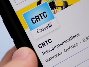 A person navigates the social media page of the Canadian Radio-television and Telecommunications Commission (CRTC) on a cell phone in Ottawa on Monday, May 17, 2021.